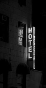 Black and white of a hotel neon sign with the word "HOT" reflected in the window.