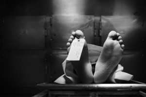 Grungy photo of feet with toe tag on a morgue table